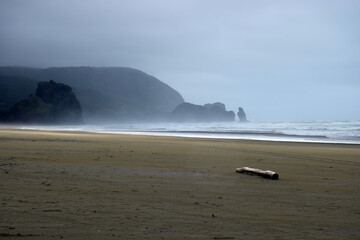 A rough windy day on a black sand beach at Piha, New Zealand