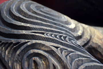 Close up detail of a carved wooden koru pattern - obrazy, fototapety, plakaty