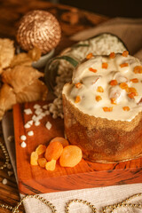 Obraz na płótnie Canvas White chocolate panettone with dried apricot on wooden table with christmas ornaments