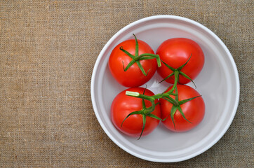 Ripe, red tomatoes in a white plate