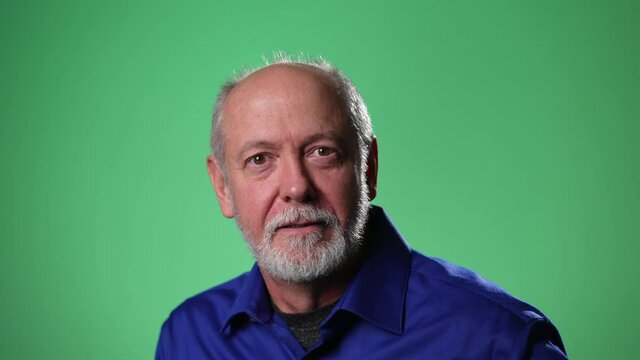 Slow motion of man shocked, saying WOW. Handsome guy with bald gray hair surprised to camera on green screen background.
