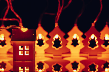 house and Christmas tree shape garlands, illuminated glow light at night