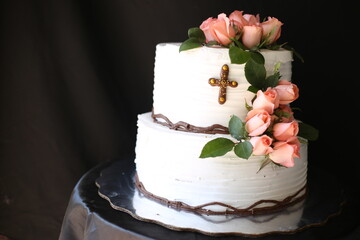 Pastel blanco con rosas y una cruz