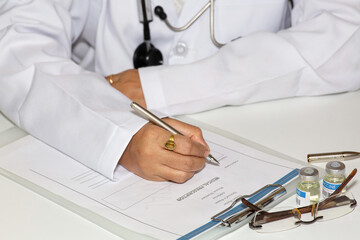 Lady doctor hands in close up writing a medical prescription at an Indian health care center