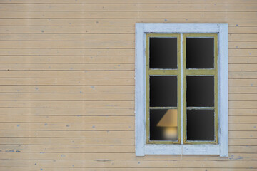 weathered wood and window with lamp inside