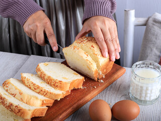 Female Chef Hold Knife to Cut or Slicing White Japanese Brioche Hokkaido Bread with Cheese Topping