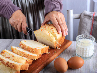 Female Home Chef Hand Cut Slicing Homemade White Japanese Brioche Loaf Bread on Wooden Board Using Knife