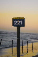 Sunset by the beach with post sign