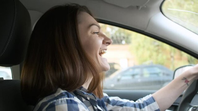 happy woman listening to music while driving a car