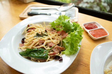 Ham spaghetti was placed on a wooden table in the cafe.