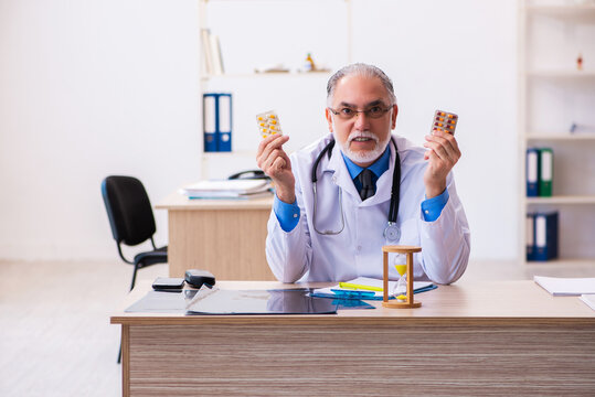 Old male doctor writing prescription in the clinic