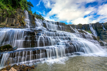 Obraz premium Waterfall early winter afternoon with water flowing over rocks and moving clouds creating spectacular beauty for the most beautiful water line highlands