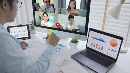 Business man talking about sale report in video conference.Asian team using laptop and tablet online meeting in video call.Working from home, Working remotely and Self isolation at home