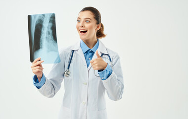 doctor with x-ray and medical gown light background stethoscope