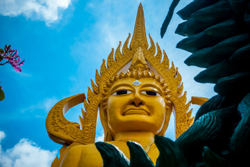 Obraz premium A huge golden Buddha statue on the territory of the temple in Phatthalung in Thailand
