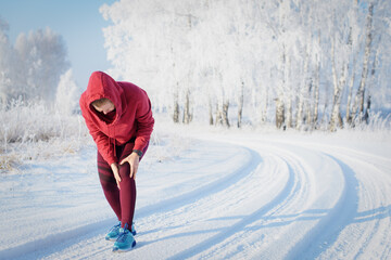 Fitness woman runner on sunny winter road.