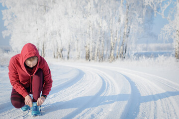 Fototapeta na wymiar Fitness woman runner on sunny winter road.