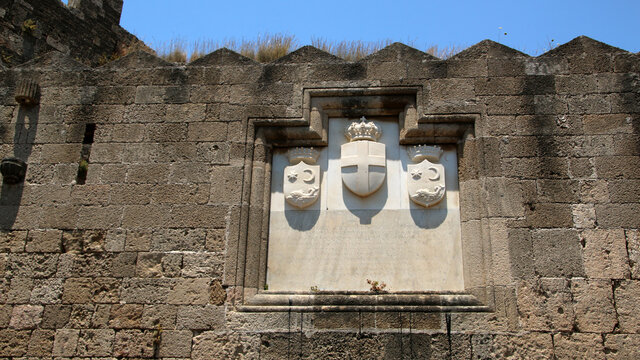 Coats of arms carved on the wall of Gate of Saint Athanasios, fortifications of Rhodes. Rhodes, Greece