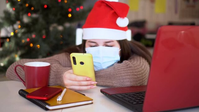 female studentin santa hat makes conference video call on laptop computer talks with web tutor, online teacher in remote webcam chat on screen. Distance education class concept.