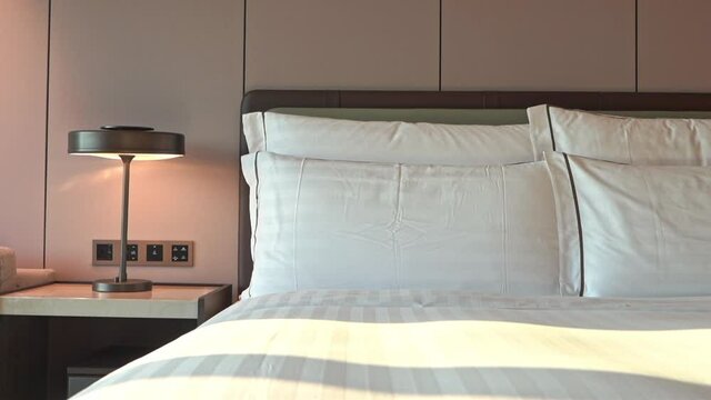 Tilt-down from headboard to multiple pillows lined up on a hotel suite bed.