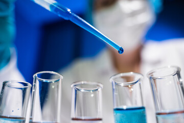 Laboratory worker pours a substance into a flask