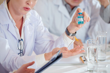 Fototapeta premium Group of scientists discussing coronavirus vaccine testing at meeting