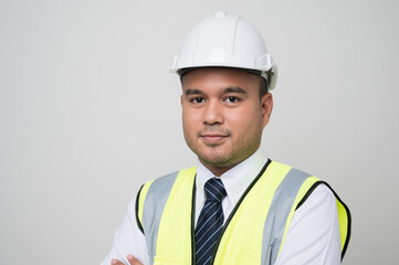 Smiling young asian civil engineer wearing helmet hard hat standing on isolated white background. Mechanic service concept.