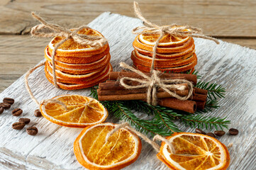 Christmas composition. Arrangement of dry Oranges, cinnamon sticks, fur tree branches and walnuts on wooden background. Rustic, Holiday spices ingredients