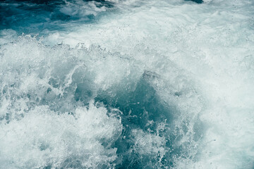 Fototapeta na wymiar Frozen splashing in rapids of powerful mountain river. Surf of clear water close-up. Nature background with tide of azure water. Frozen motion of splashes. Backdrop of only water. Full frame of tide.