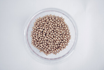 a bowl full of golden beads view from the top.