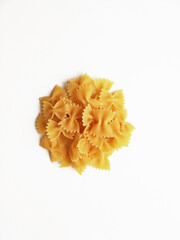 uncooked pasta farfalle in the center in the shape of a circle on a white background top view