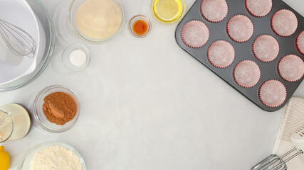 Muffin pan with paper cupcake liners, and ingredients for chocolate muffin recipe close up on...