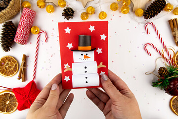 DIY step-by-step instructions for a Christmas card with children. Volumetric snowman on a postcard...