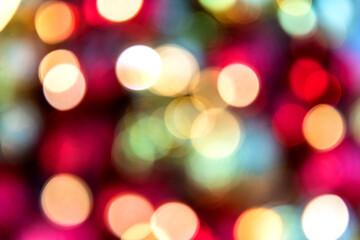 Obraz premium Gold and red bokeh abstract background with defocused lights and Christmas balls.
