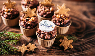 Chocolate cupcakes with star shaped cookies on a wooden background. Christmas mood. Sweets for any occasion