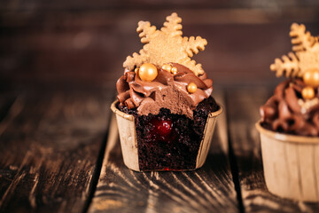 Chocolate cupcakes with star shaped cookies on a wooden background. Christmas mood. Sweets for any occasion. Cupcake cut, fruit filling