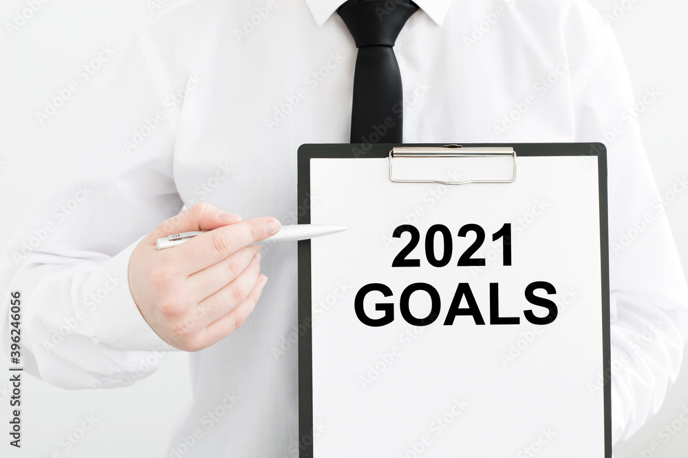 Poster card with text goals 2021 in the hands of a man on a light background
