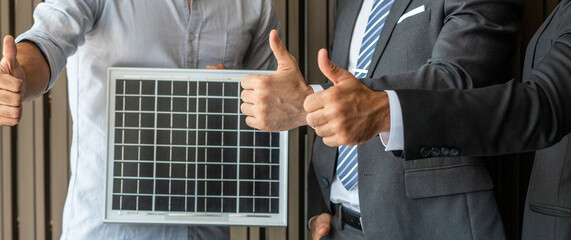 Business men and engineer express support by showing thumps up to a new project for solar energy on...