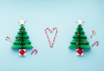 Christmas card - Xmas paper green tree, candy canes and gift boxes on blue background.