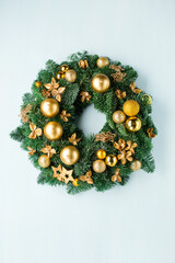 Advent christmas wreath or crown with golden candles on blue wooden background. © Iuliia Metkalova