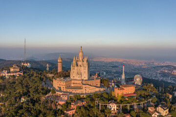 Fototapeta premium Aerial drone view of Basilica Sacred Heart on Mount Tibidabo near Barcelona during sunset golden hour