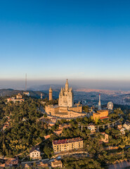 Naklejka premium Aerial drone view of Basilica Sacred Heart on Mount Tibidabo near barcelona during sunset golden hour