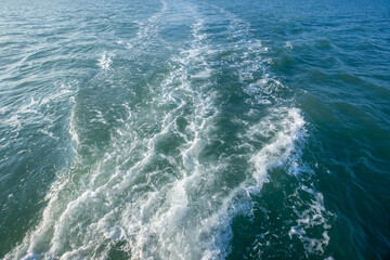 Ripped water surface, ocean waves on the sea with sunlight by yacht trip