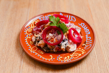 Vegetable salad with mayonnaise. Delicious mayonnaise salad on a plate. Over rustic wooden background.