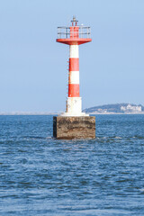 Lighthouse on the sea against blue sky and blue ocean surface