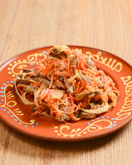Vegetable salad with mayonnaise. Delicious mayonnaise salad on a plate. Over rustic wooden background.