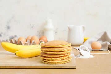 Fototapeta na wymiar Tasty banana pancakes with ingredients on table
