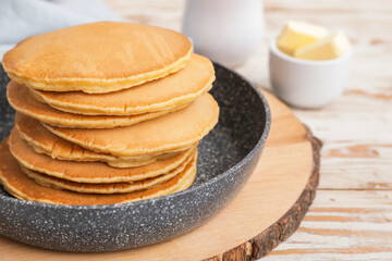 Frying pan with tasty banana pancakes on table