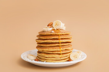 Tasty banana pancakes on color background