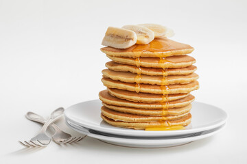 Tasty banana pancakes on white background